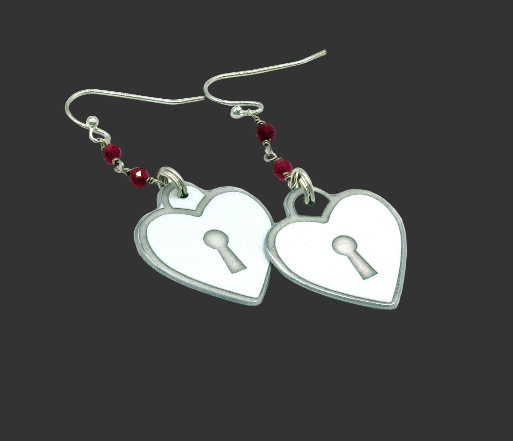 Heart-shaped earrings with keyholes on a white background