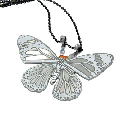 Butterfly-shaped pendant on a chain against a white background