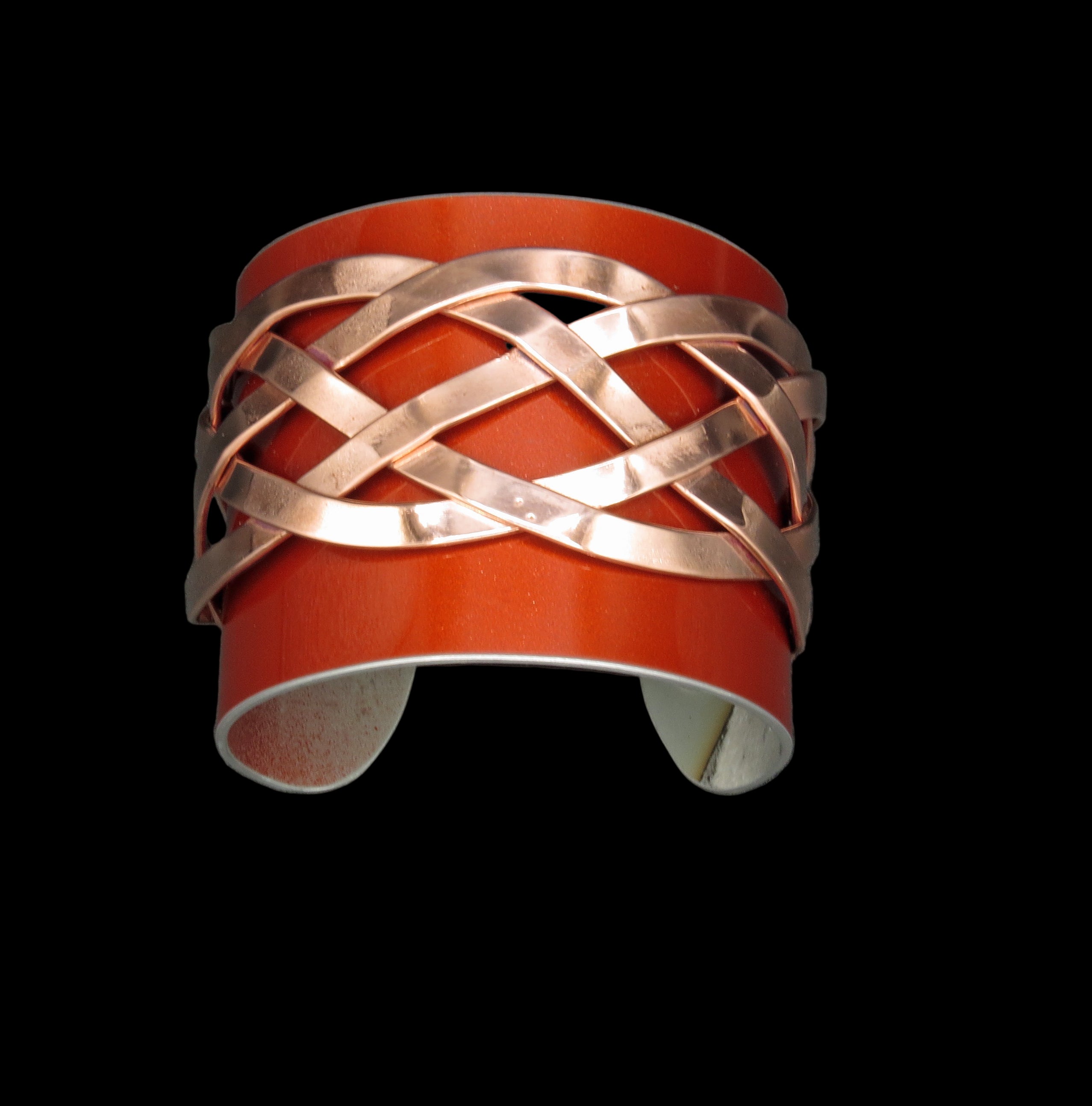 Copper bracelet with braided design on a gray background